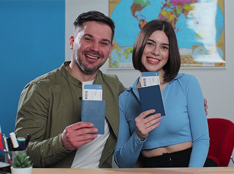 Happy woman holding flight tickets at desk