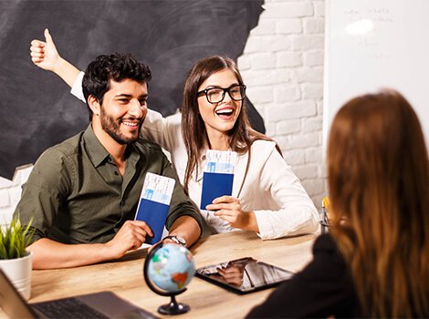 Happy woman holding flight tickets at desk
