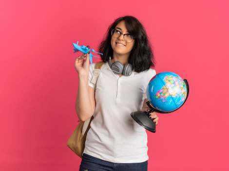 Happy woman holding flight tickets at desk